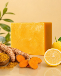 Turmeric kojic acid soap bar surrounded by fresh turmeric root and lemon
